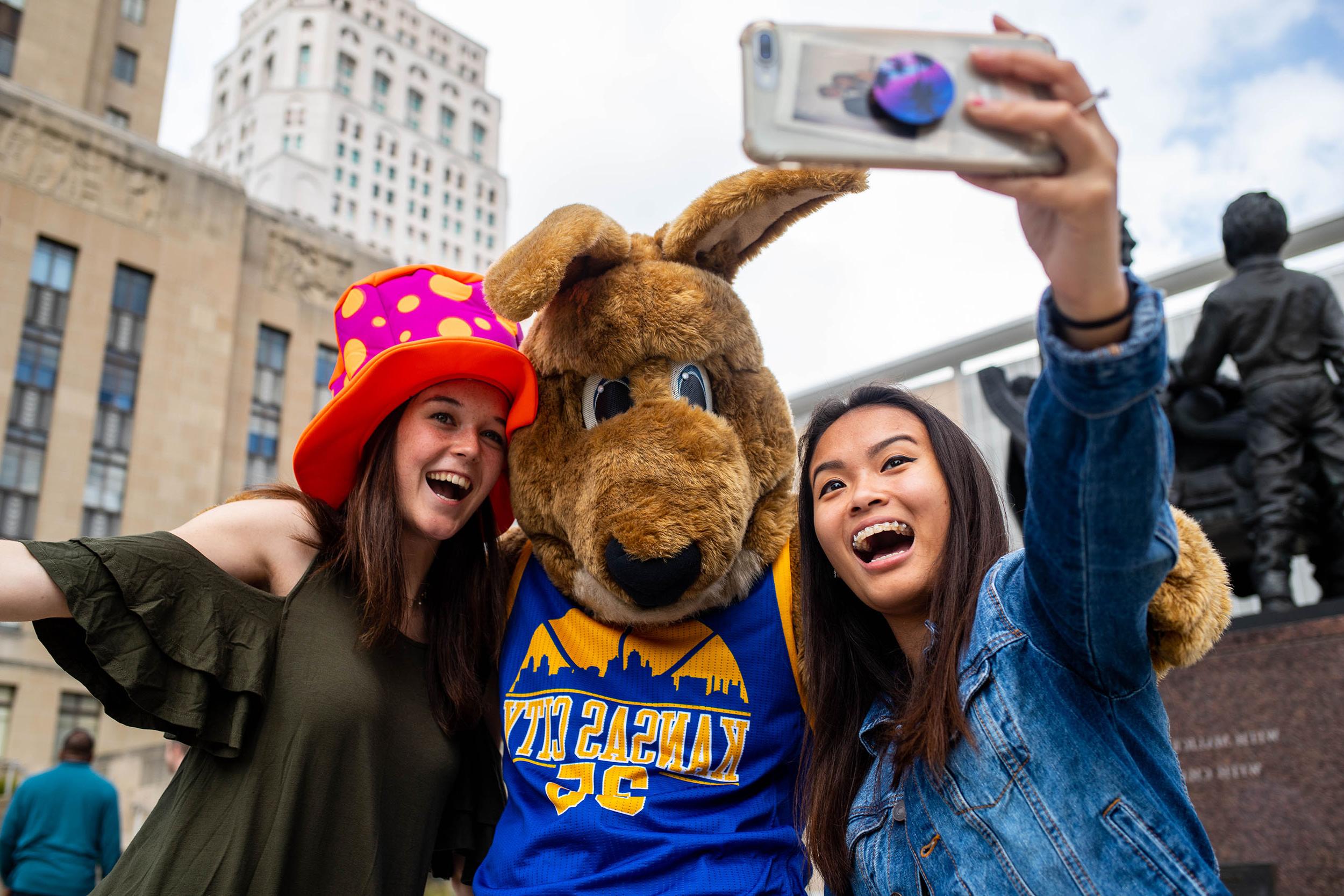 Two students pose with Kasey the UMKC kangaroo mascot